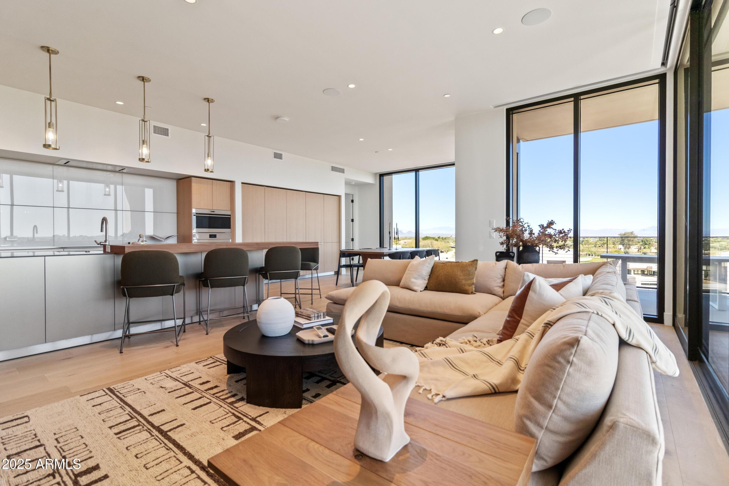 a living room with furniture potted plant and large windows