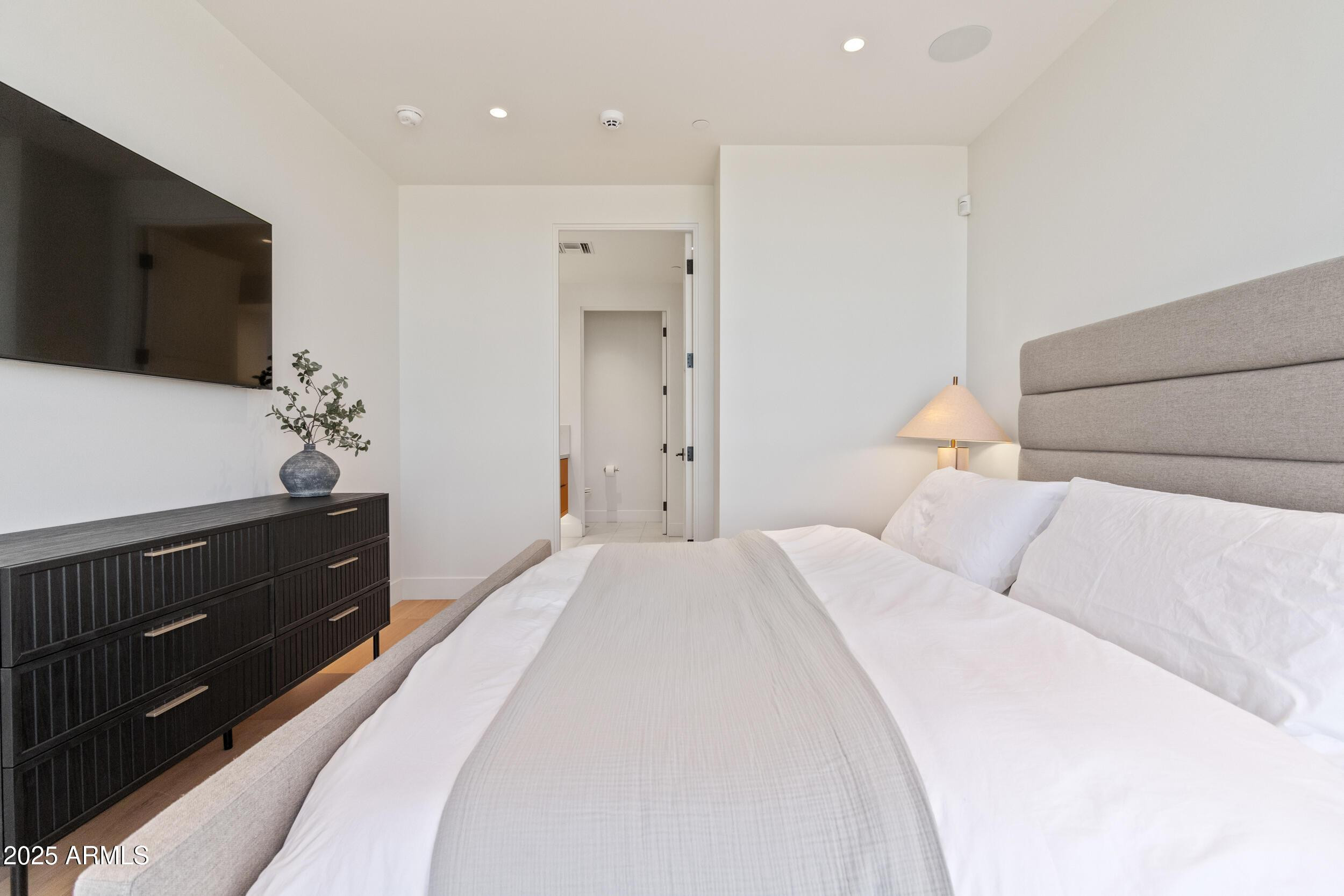 5000 North Camelback Ridge Drive, Unit 302 Scottsdale, AZ 85251 - Photo 18 of 42 a large bedroom with a bed and a flat screen tv