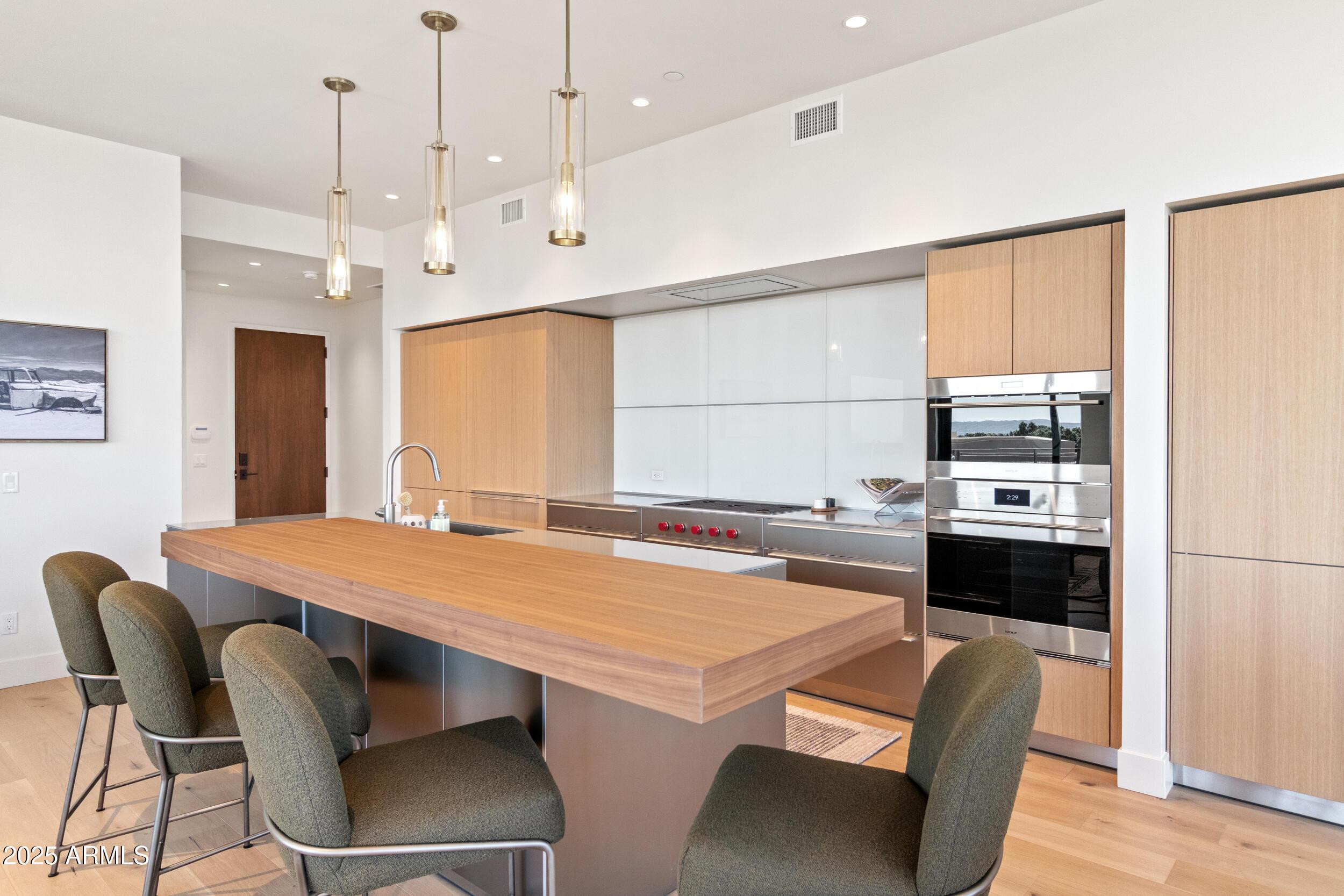 5000 North Camelback Ridge Drive, Unit 302 Scottsdale, AZ 85251 - Photo 10 of 42 a kitchen with a stove a refrigerator and a dining table