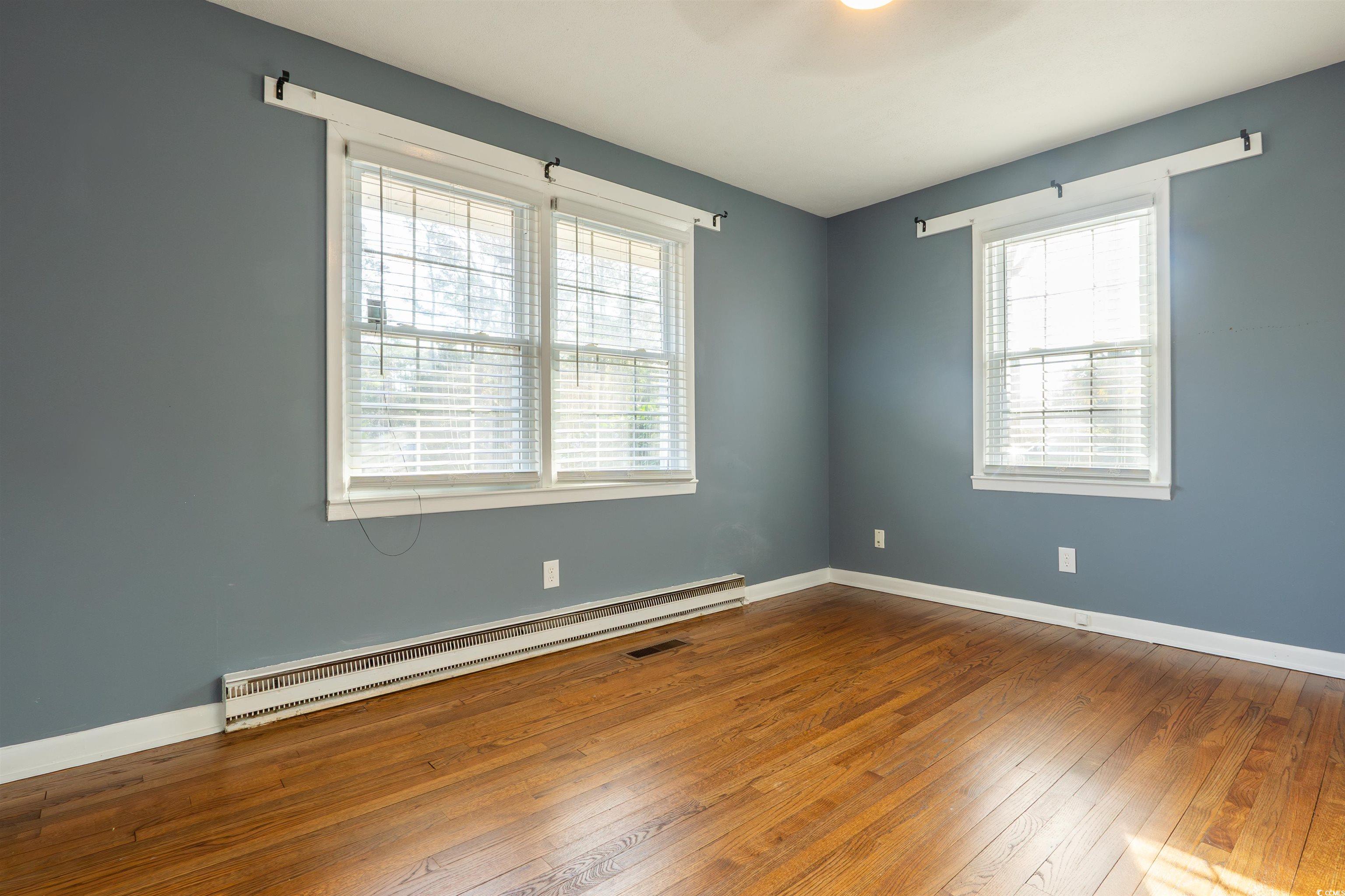 1105 Scott Drive Myrtle Beach, SC 29577 - Photo 5 of 13 Empty room with a baseboard heating unit and hardw