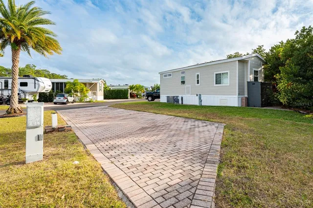 a view of a house with a yard and potted plants
