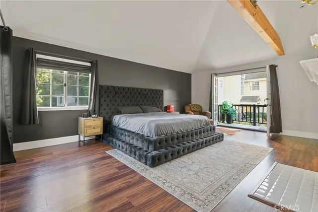 a bedroom with a bed a table and windows