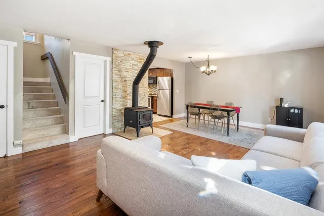 a living room with furniture and a dining table with wooden floor