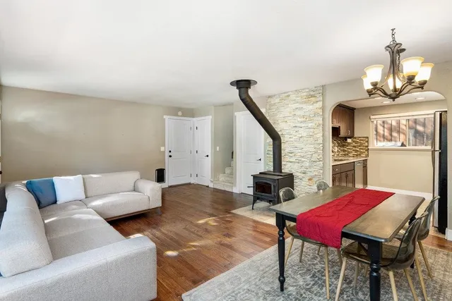 a living room with furniture a fireplace and a chandelier