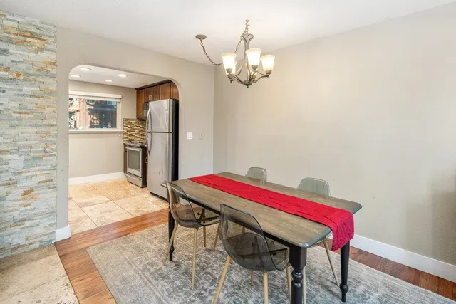 a room with a table chairs and kitchen view