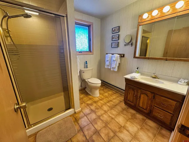 a bathroom with a granite countertop sink toilet and shower