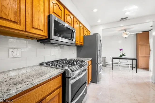 a kitchen with stainless steel appliances granite countertop a stove and a microwave