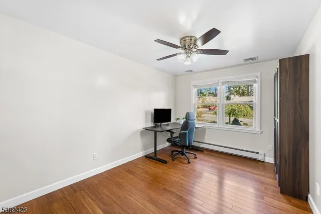 a view of workspace with wooden floor and a window
