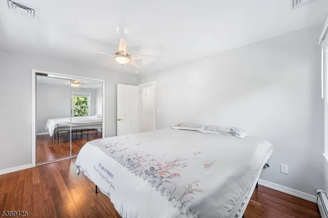 a bedroom with a bed a dresser and window