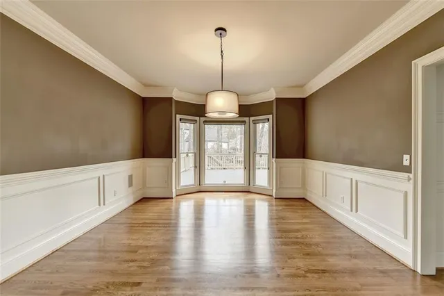 a view of a dining room with furniture a rug and wooden floor