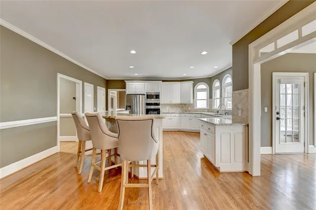 a spacious bathroom with a granite countertop sink a mirror a bathtub and a shower