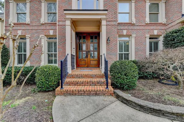 a view of an empty room with wooden floor and windows