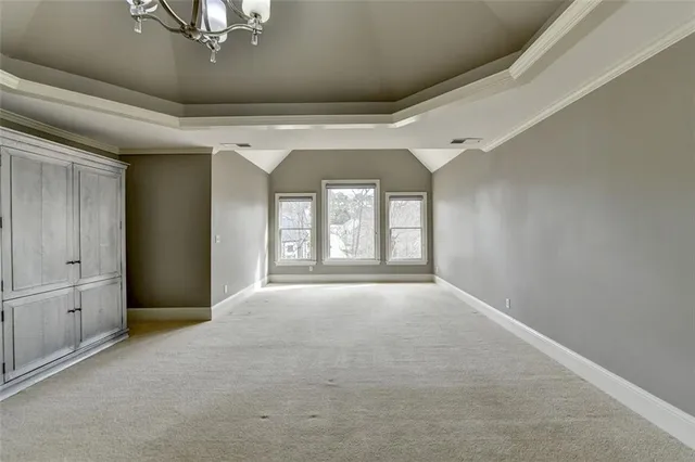 a view of an empty room with wooden floor and closet