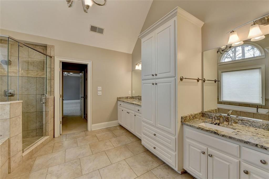 7830 Tintern Trace Duluth, GA 30097 - Photo 51 of 91 a spacious bathroom with a granite countertop sink a mirror and a shower