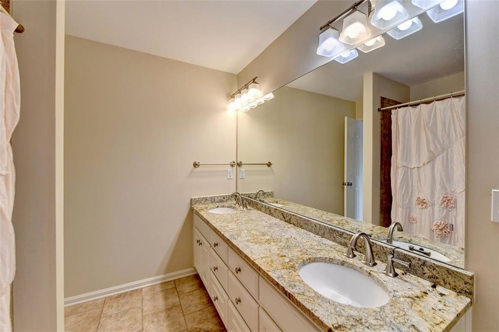 7830 Tintern Trace Duluth, GA 30097 - Photo 60 of 91 a bathroom with a granite countertop sink a light fixture and a mirror