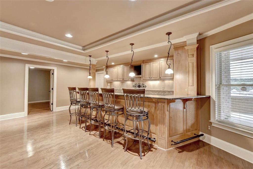 7830 Tintern Trace Duluth, GA 30097 - Photo 75 of 91 a kitchen with stainless steel appliances kitchen island granite countertop a table chairs and a refrigerator