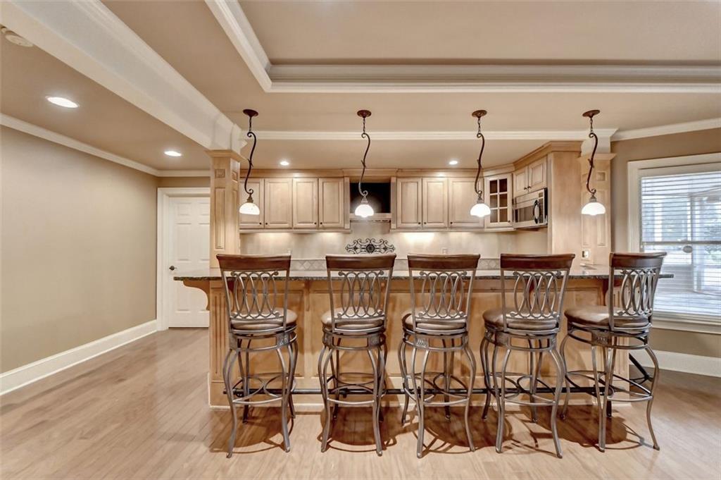 7830 Tintern Trace Duluth, GA 30097 - Photo 77 of 91 a kitchen with stainless steel appliances kitchen island granite countertop a table and chairs