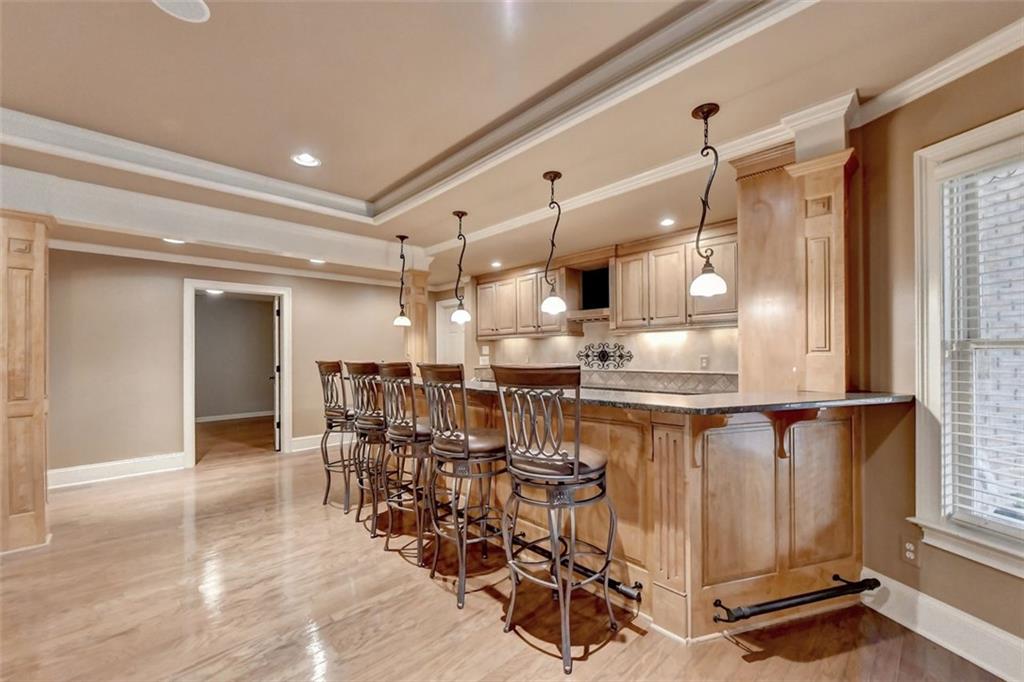 7830 Tintern Trace Duluth, GA 30097 - Photo 78 of 91 a kitchen with stainless steel appliances kitchen island granite countertop a table chairs in it and wooden floors