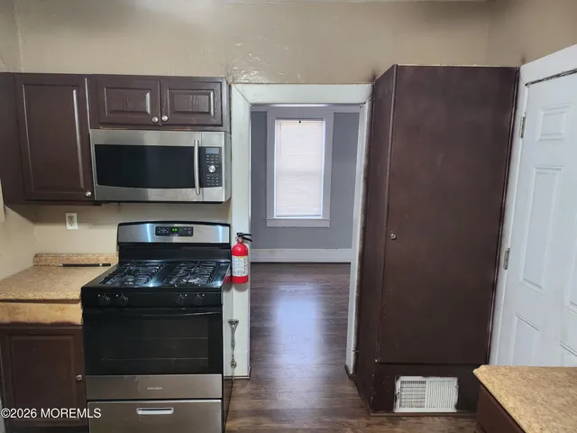 a kitchen with wooden cabinets and a stove top oven