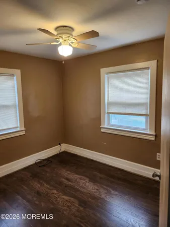 a view of a room with wooden floor and a window
