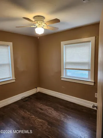 a view of a room with wooden floor and a window