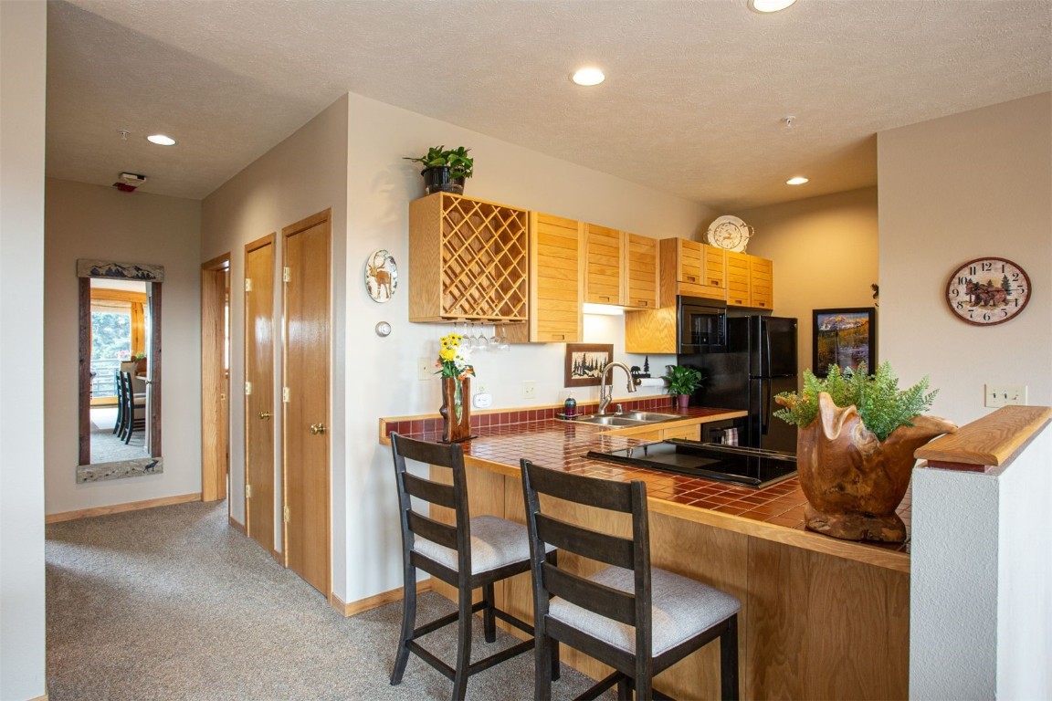 91400 Ryan Gulch Road, Unit 419 Silverthorne, CO 80498 - Photo 9 of 34 a room with a table chairs and a refrigerator