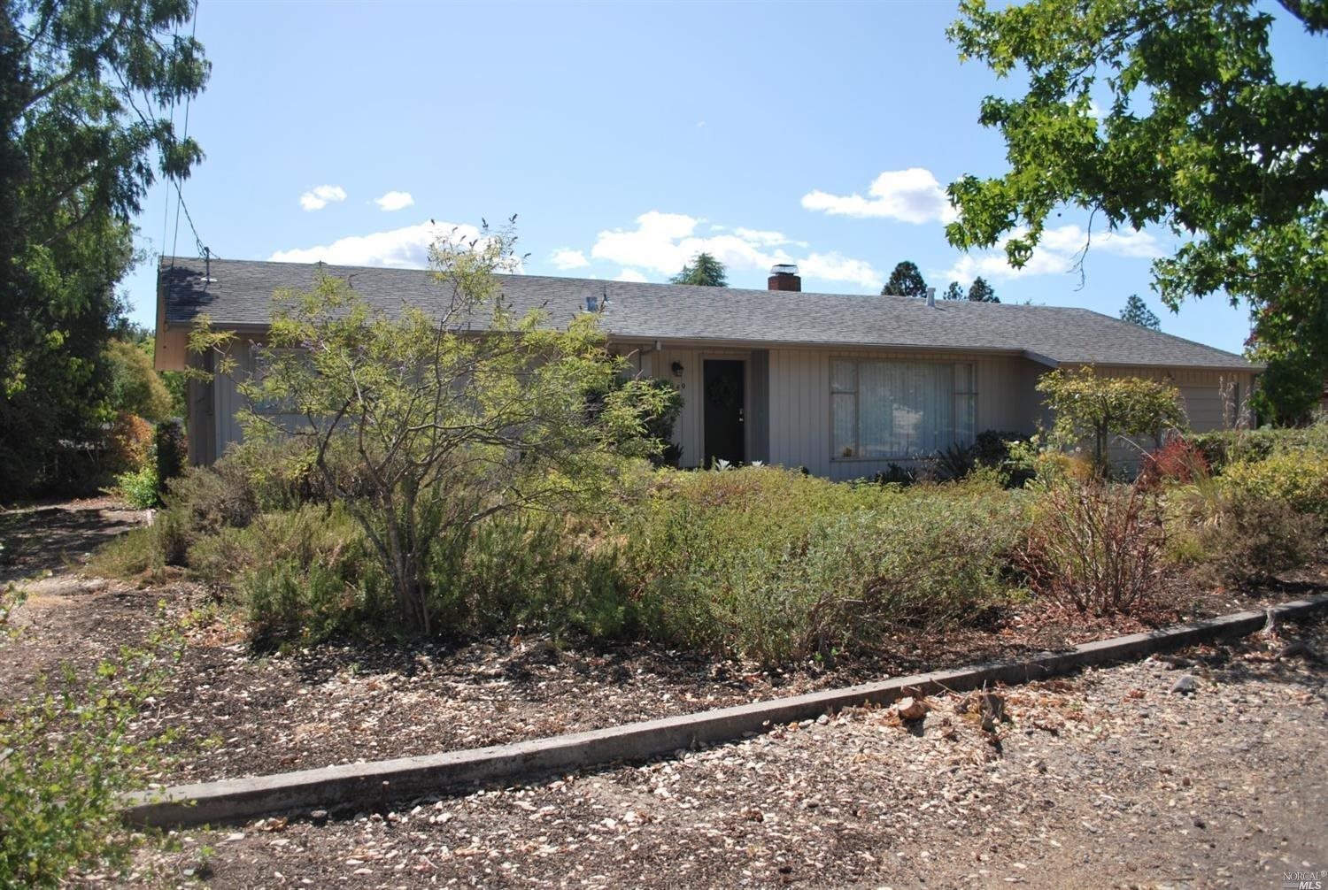 a view of a house with a yard and potted plants