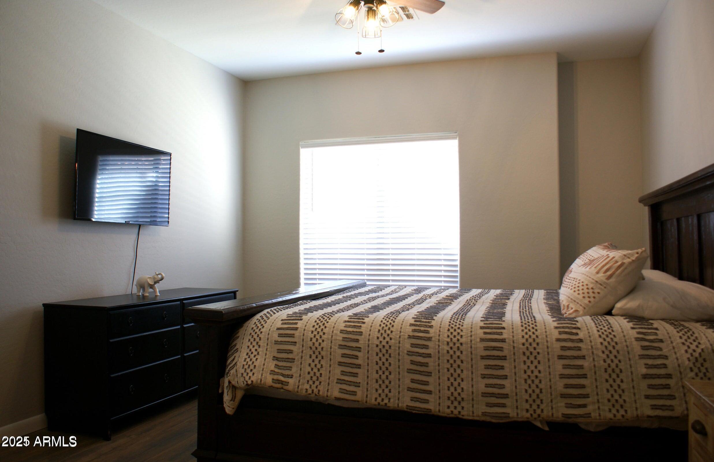 525 North Miller Road, Unit 145 Scottsdale, AZ 85257 - Photo 3 of 9 a bedroom with a bed and a flat screen tv