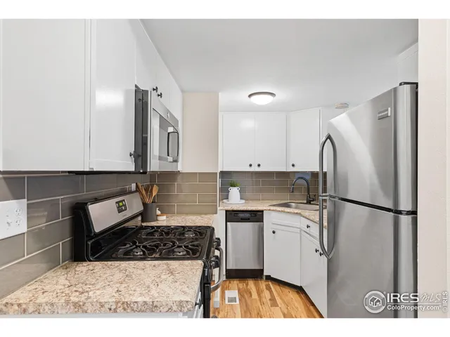 a kitchen with a sink a refrigerator and a stove top oven