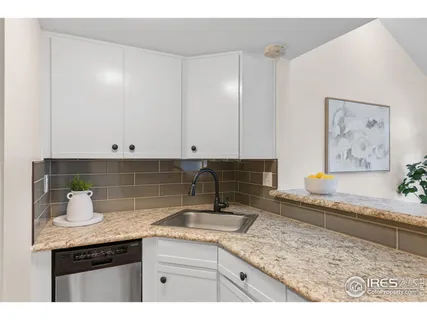 a kitchen with granite countertop a sink a stove and cabinets