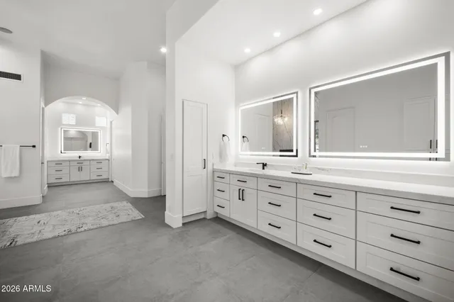 a spacious bathroom with double vanity and a mirror