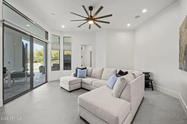 a living room with furniture and large windows