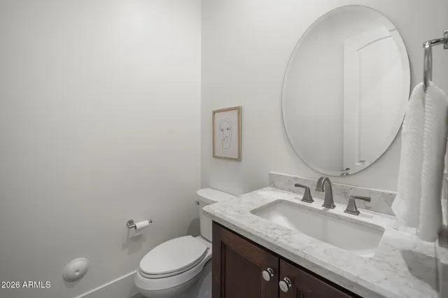 a bathroom with a granite countertop toilet a sink and a mirror