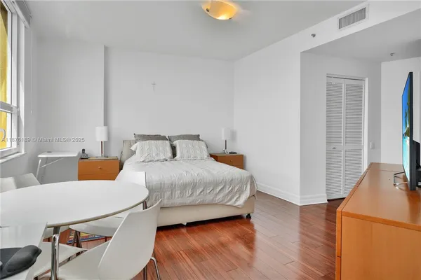 a bedroom with a bed and wooden floor