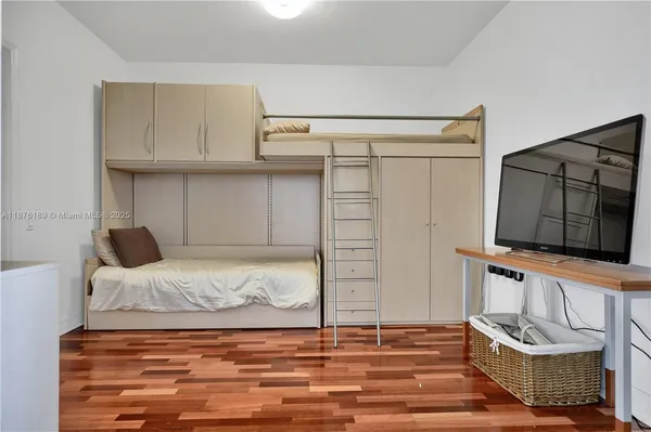a bedroom with a bed and flat screen tv