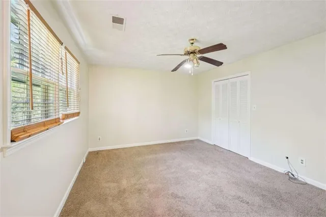 a view of room with a ceiling fan and window