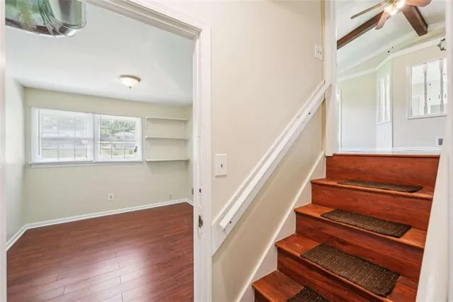 a view of staircase with wooden floor and fan