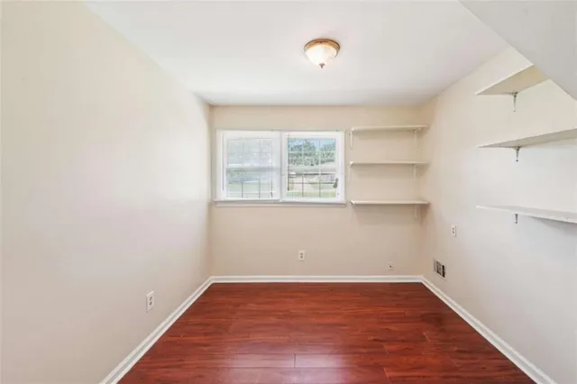 a view of a kitchen with wooden floor and a window