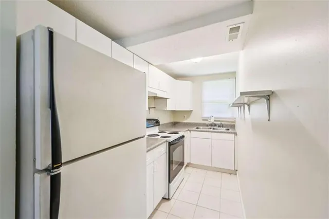 a kitchen with stainless steel appliances granite countertop white refrigerator stove a sink and dishwasher