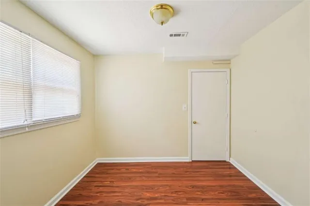 a view of a livingroom with wooden floor and window