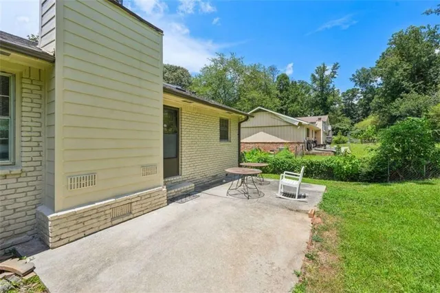 a view of a patio with a table and chairs under an umbrella