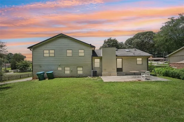 a view of a house with a yard and sitting area
