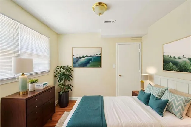 a bedroom with a bed and a potted plant