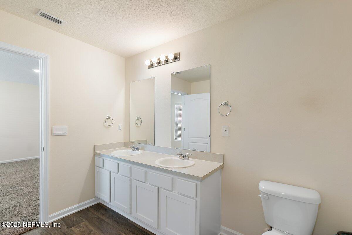 233 Falcon Ridge Road St. Augustine, FL 32084 - Photo 14 of 34 a bathroom with a toilet a sink and mirror
