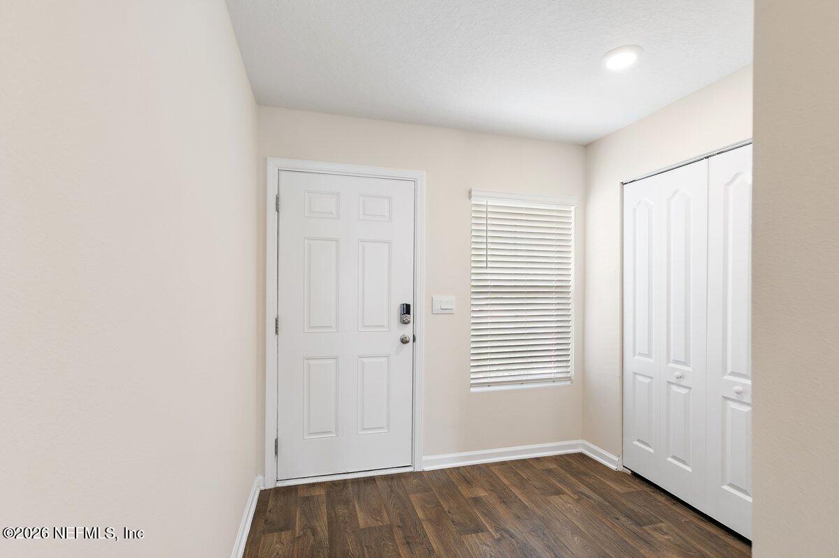 233 Falcon Ridge Road St. Augustine, FL 32084 - Photo 3 of 34 an empty room with wooden floor and windows