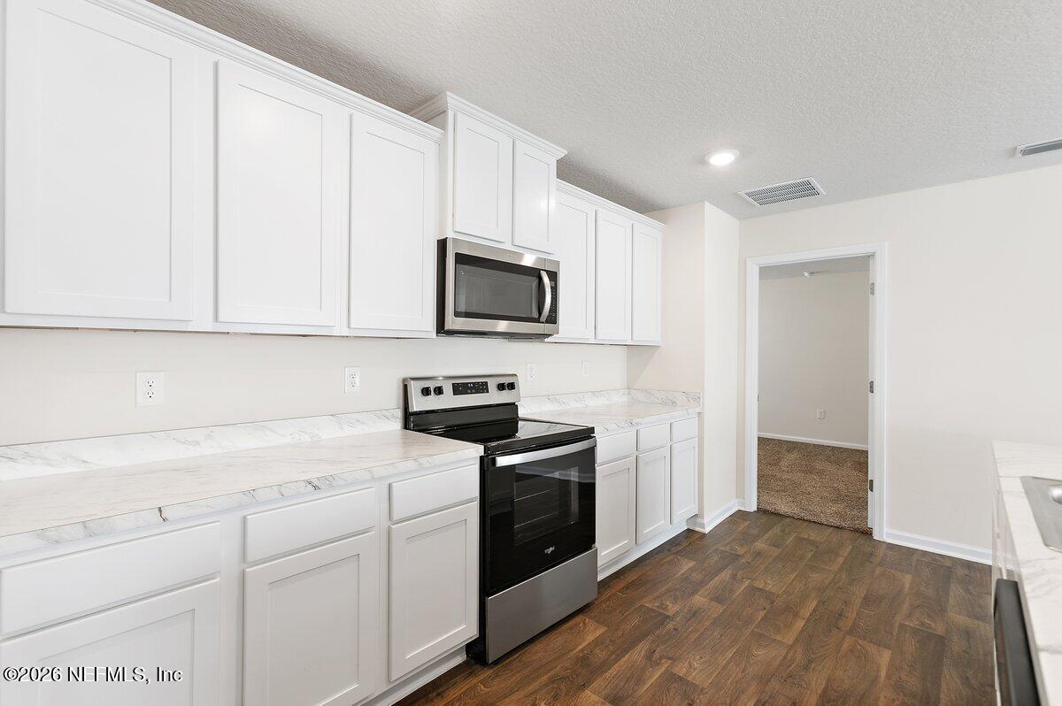 233 Falcon Ridge Road St. Augustine, FL 32084 - Photo 9 of 34 a kitchen with a sink stove and microwave