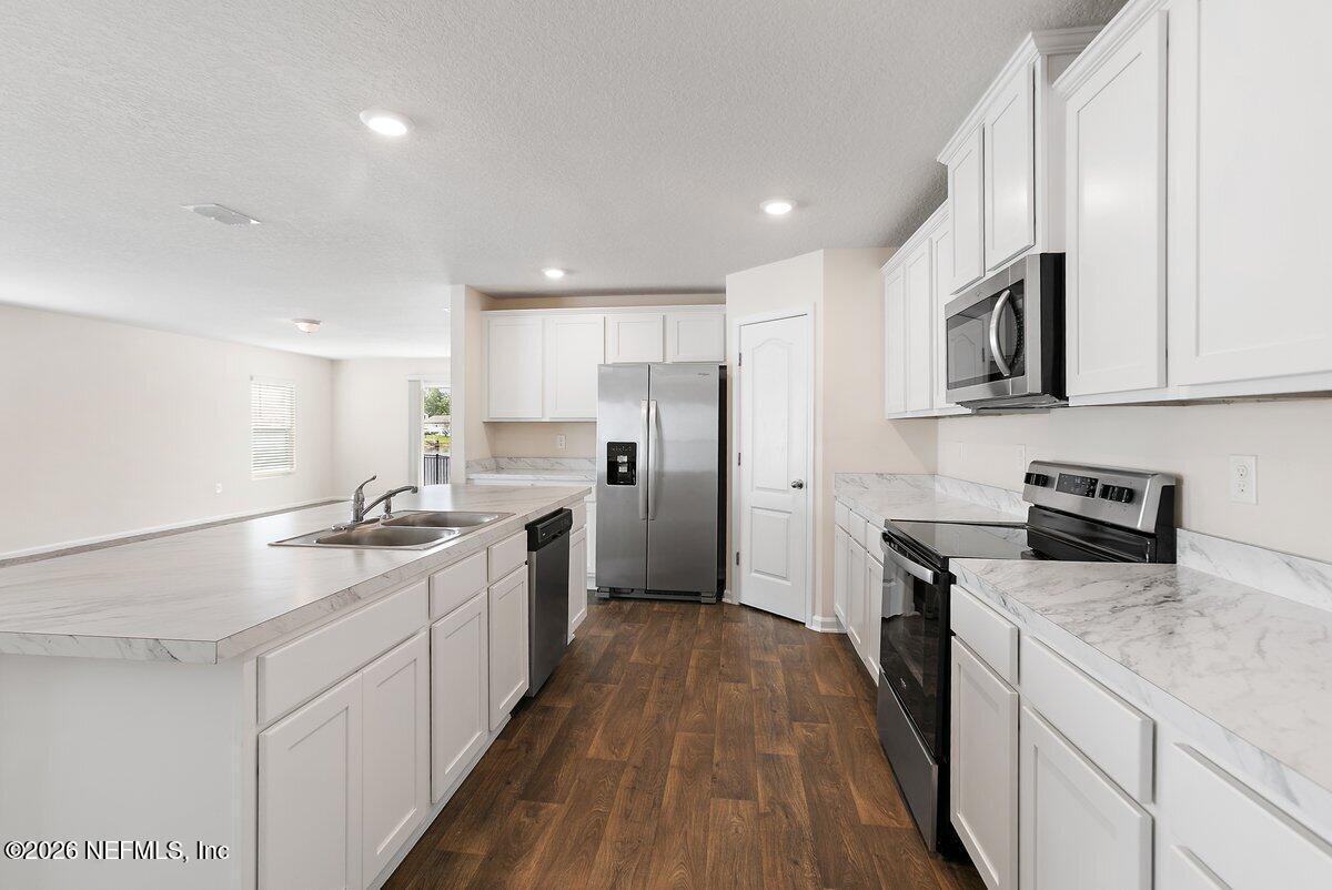 233 Falcon Ridge Road St. Augustine, FL 32084 - Photo 10 of 34 a kitchen with a sink stove top oven and refrigerator