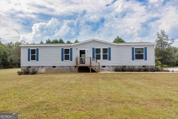 a front view of house with yard and trees
