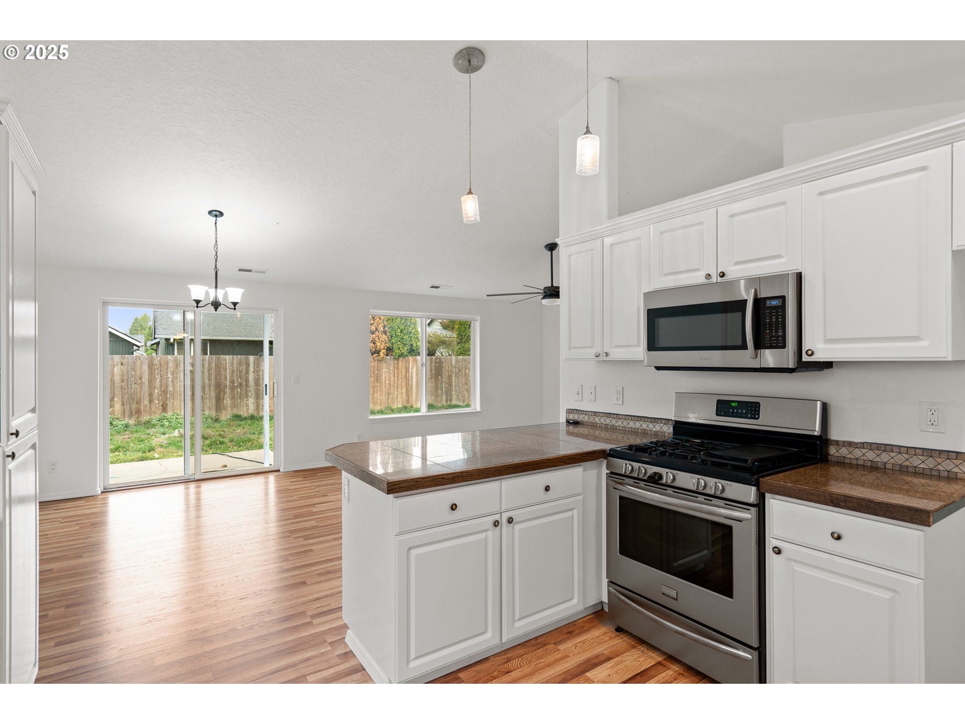 1237 South 7th Street Independence, OR 97351 - Photo 11 of 29 a kitchen with stainless steel appliances granite countertop a stove a sink and a microwave