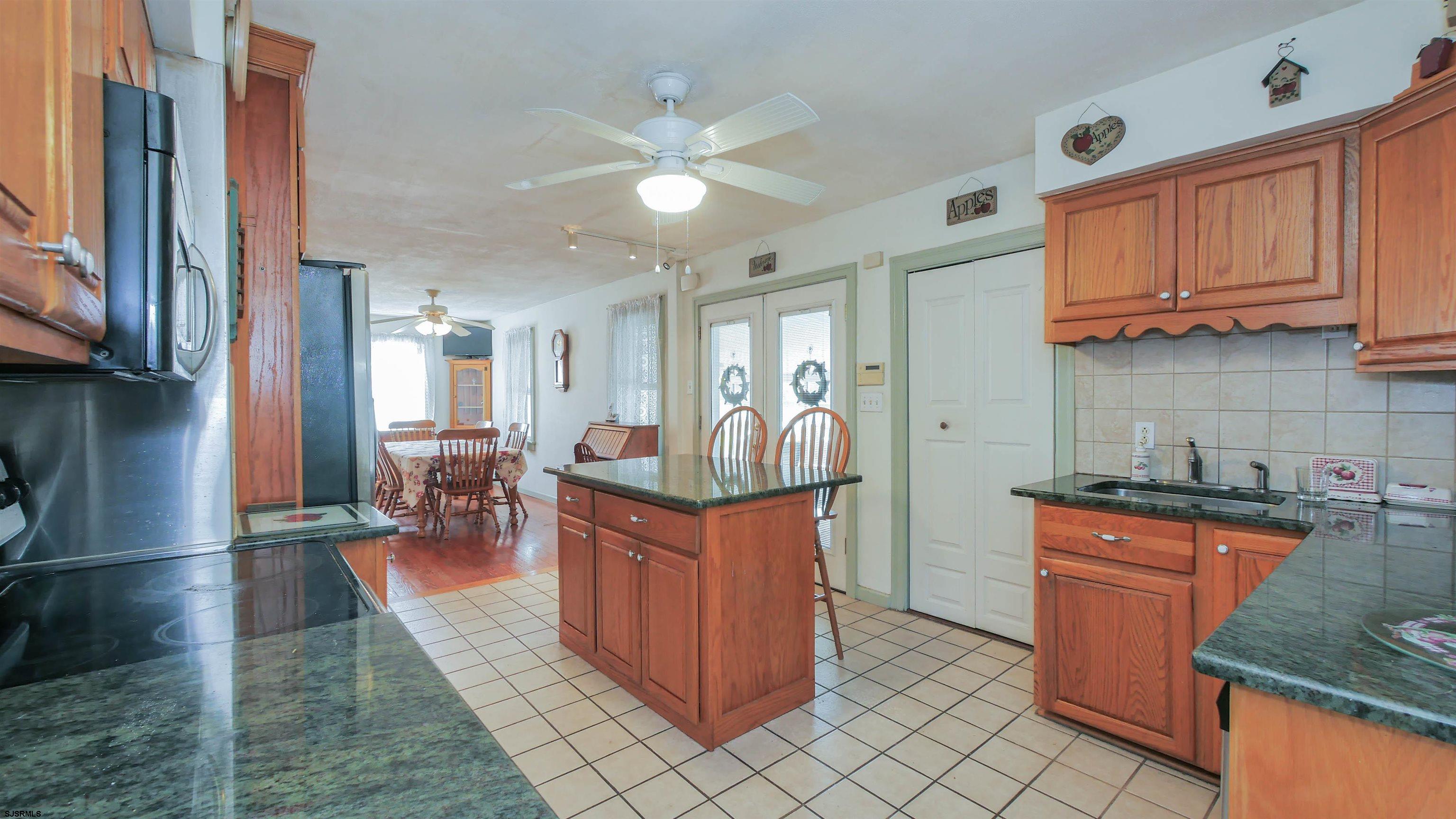 346 Tuckahoe Road Vineland, NJ 08360 - Photo 12 of 44 a kitchen with stainless steel appliances granite countertop a stove top oven a sink dishwasher and cabinets with wooden floor